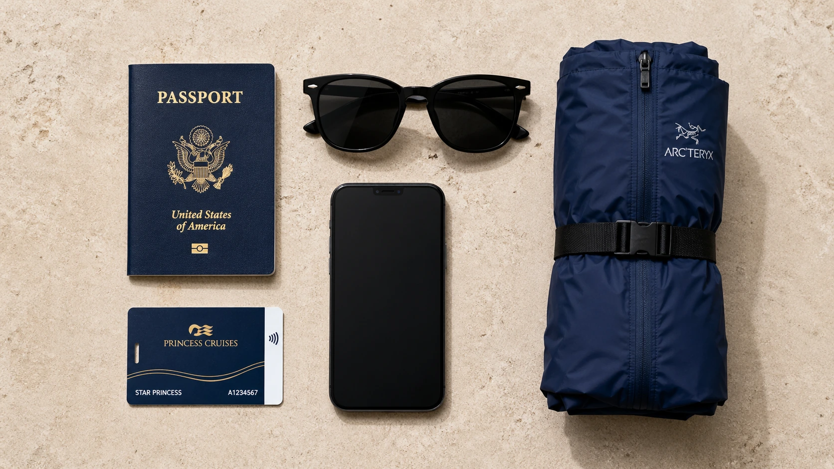 Flat-lay knolling photograph of premium travel items neatly organized on a sandstone surface
