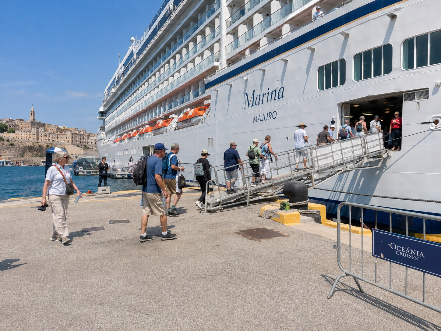 A cruise ship docked at a sunlit port, with passengers boarding